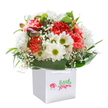 With a joyful burst reminiscent of a walk through Hillingdon's leafy avenues, this stunning floral bouquet is freshly arranged and upright in a modern, white square gift bag ready for a friendly doorstep delivery. The star attractions-soft coral and peach carnations-stand out with their plush, frilly petals, while playful white daisies, each with zesty lime-green centers, bring an energizing lift. Baby's breath is sprinkled throughout, its delicate, cloud-like florets giving the whole bouquet a sense of movement and grace. On the left side, a few purple-tinged buds peek shyly, adding a dash of intrigue to the well-balanced palette. All the flowers are embraced by a thick band of glossy, deep green foliage, echoing the peaceful corners of Fassnidge Park. Every element-right down to the white ribbon handles on the bag and the pristine background-is selected to showcase freshness, colour, and heartfelt care. Perfect as a surprise for a birthday, a thank you, or to brighten any home around Hillingdon, this bouquet is a celebration of local floristry at its most personal and inspiring.